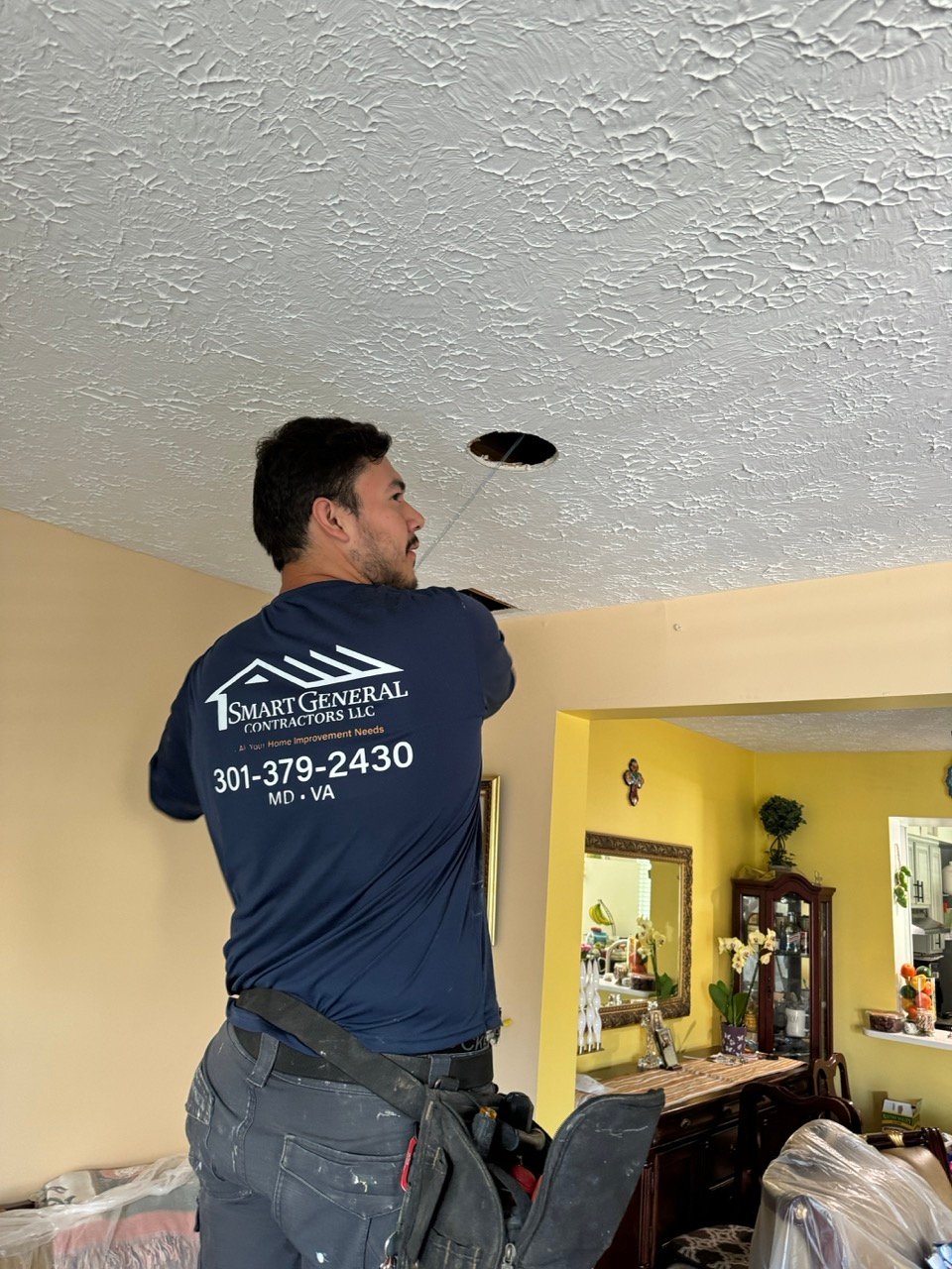 David Jr., Head Contractor at Smart General Contractors, installing lighting in a residential home