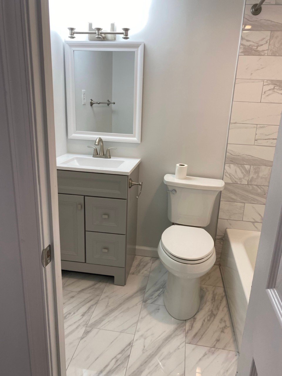 Fully remodeled bathroom with new tile, vanity, and modern fixtures