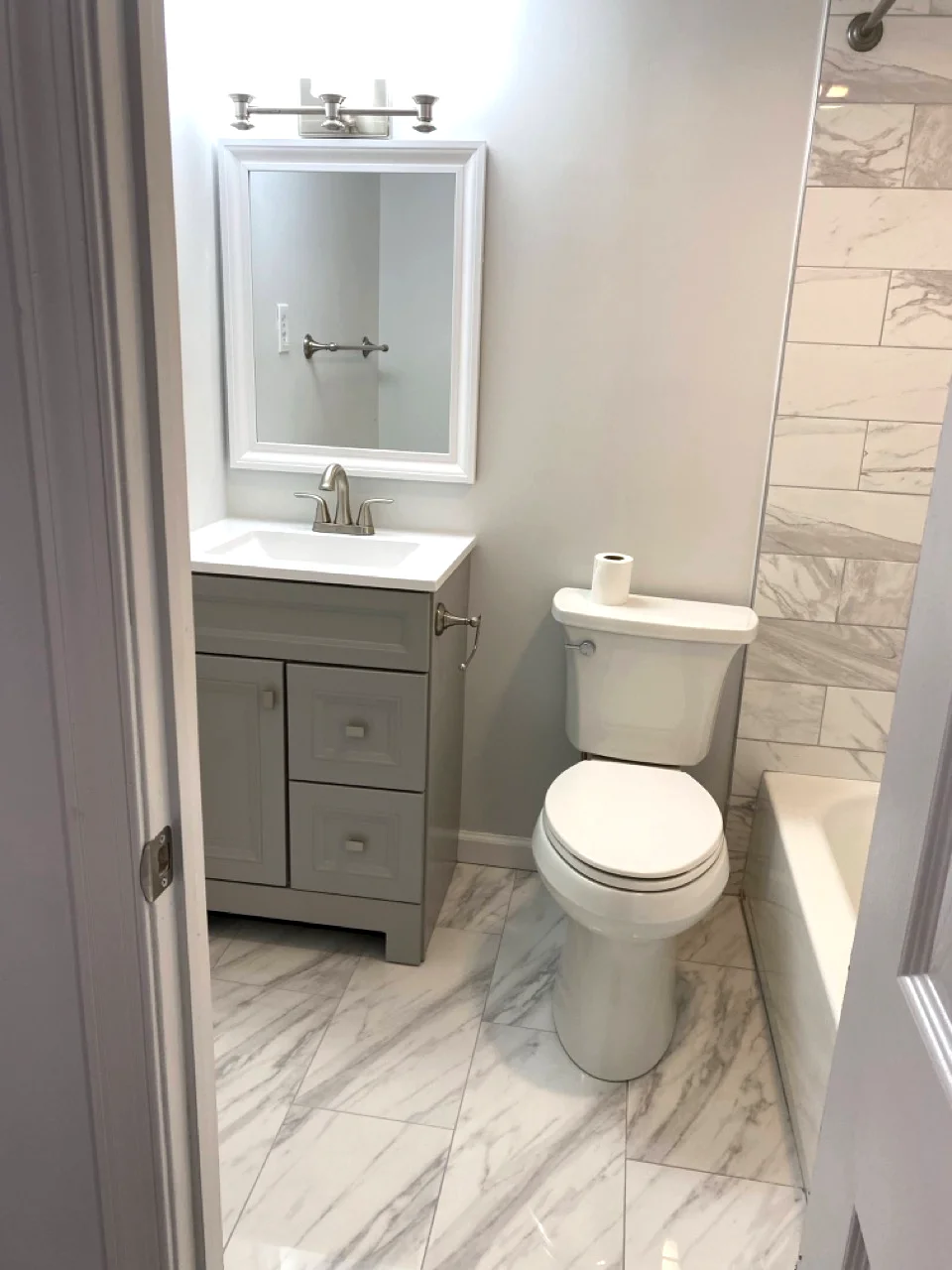 Fully remodeled bathroom with new tile, vanity, and modern fixtures